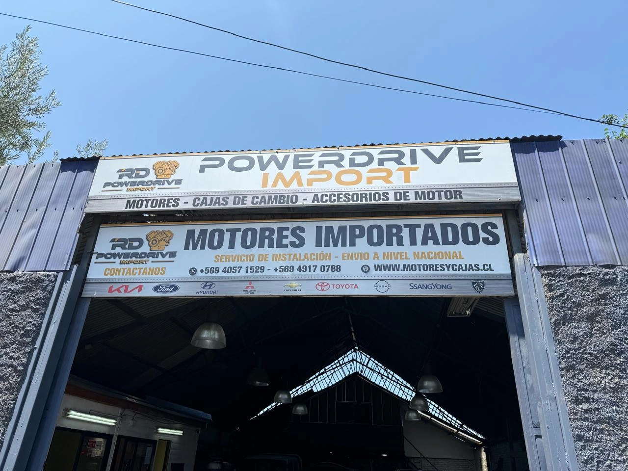 Entrada real del local Power Drive Import RD en Renca, con los letreros Powerdrive Import y Motores importados